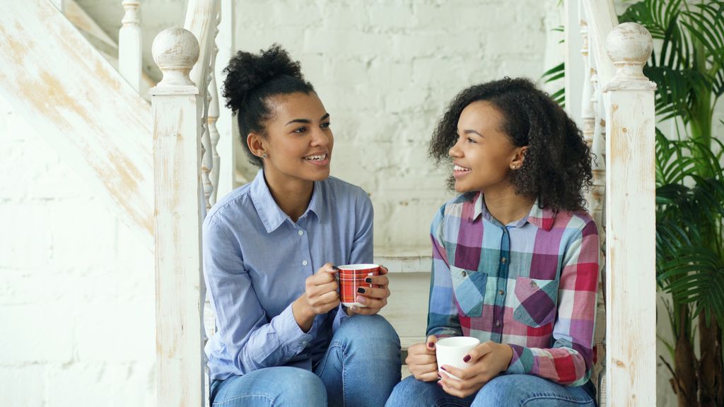 Mother and teenage daughter talking over a cup of tea