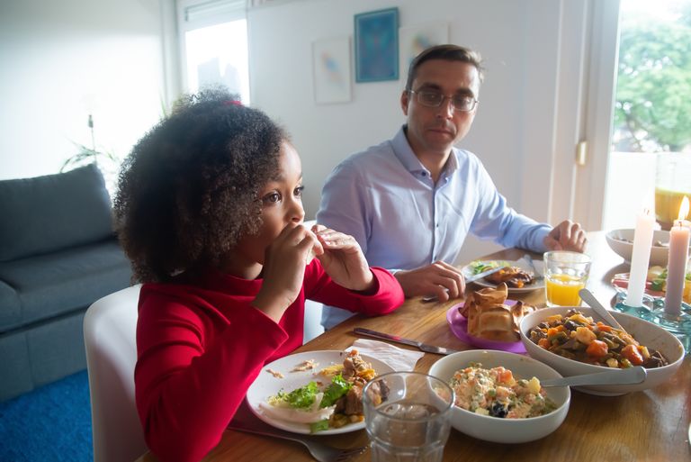 Parent and child enjoying a relaxed family meal while exploring a variety of vegetables together