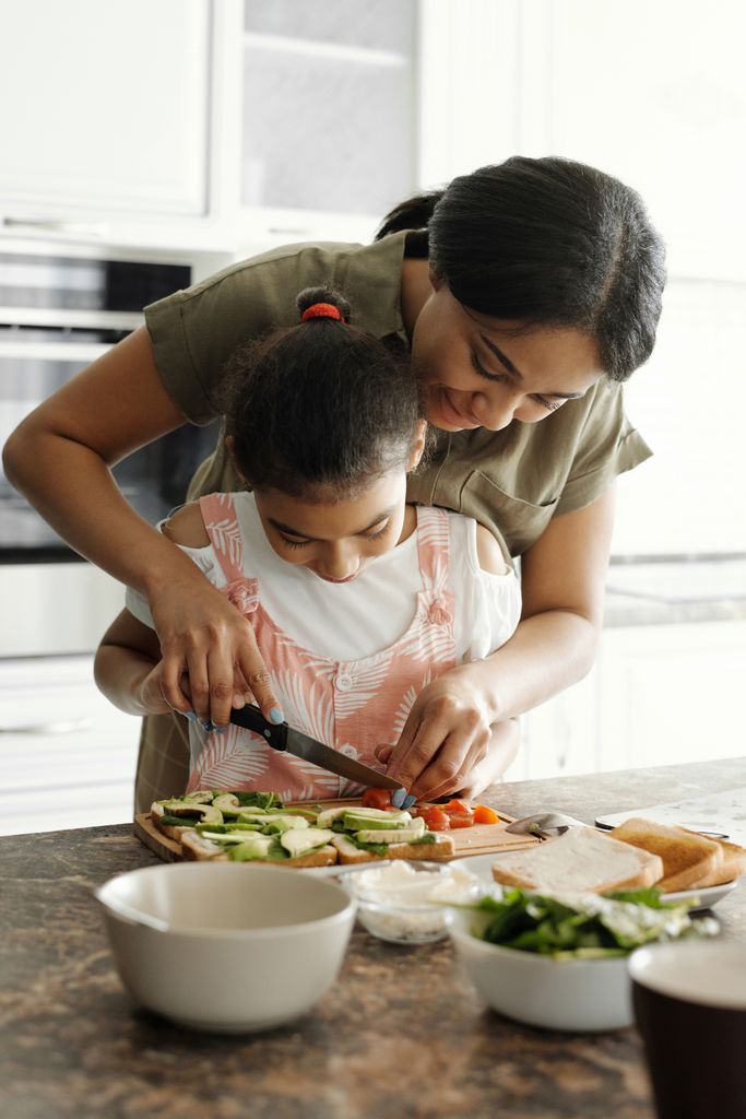 Parent and child preparing vegetables together
